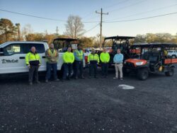 McCall Pest & Wildlife team members standing in front of heavy machinery vehicles